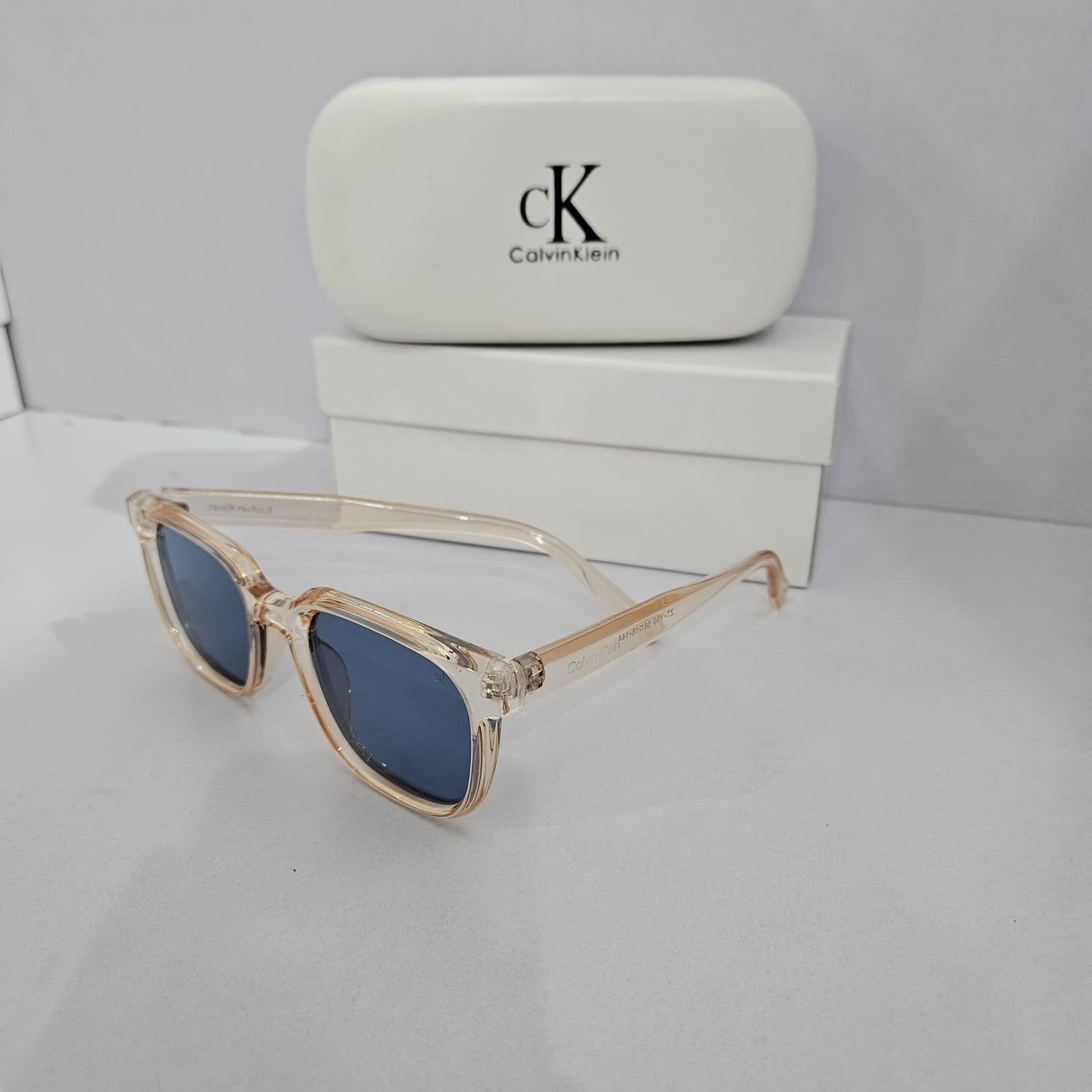 CALVIN KLEIN Ethereal Blush Transparent Frame Sunglasses with Azure Lenses
